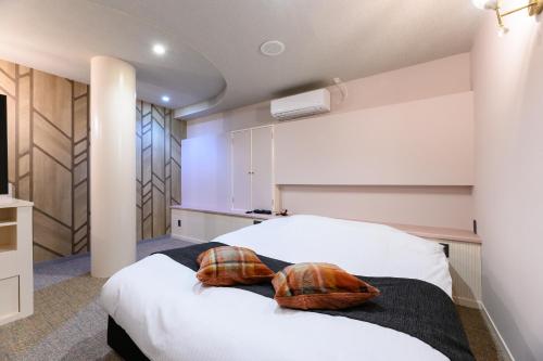a bedroom with a bed with two pillows on it at HOTEL FARINA DOLCE (Adult Only) in Kanuma