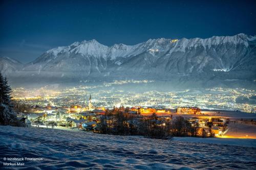 a town in the snow at night with a mountain at Das Sill by Inncomer in Innsbruck