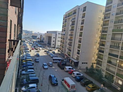 a city street with cars parked in a parking lot at Comfort Apartment, New City Center - Free Parking in Ferizaj