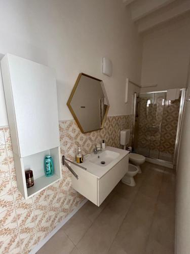 un bagno con lavandino, WC e specchio di Villa Bonaccorso - antica e maestosa villa con piscina ai piedi dell'Etna a Viagrande
