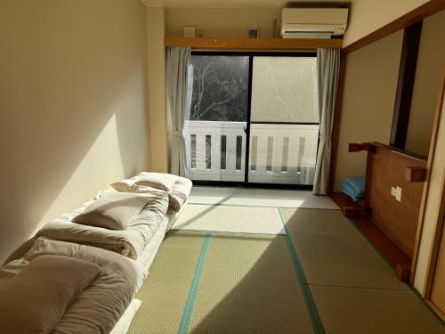 a living room with a couch and a large window at 波のたわむれ in Kami Amakusa