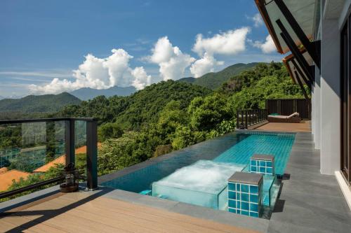 a swimming pool with a view of the mountains at Banyan Tree Lang Co in Lang Co