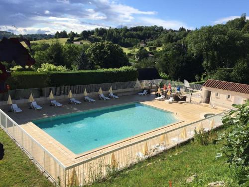 une grande piscine avec des chaises longues et une clôture dans l'établissement Les Hauts de Sarlat G4 - Clim Piscine Parking WiFi 2 Chambres, à Sarlat-la-Canéda