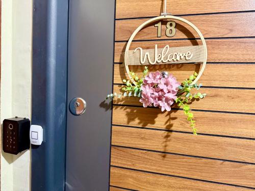 a door with a welcome sign and flowers on it at Resita Dream Apartament in Reşiţa