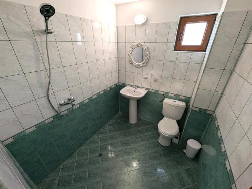 a bathroom with a shower and a toilet and a sink at Guest house Sineva in Primorsko
