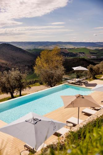 a large swimming pool with umbrellas and chairs at Antichi Casali di Charme in Orvieto