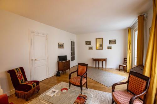 un salon avec deux chaises et une table dans l'établissement Parisian Home 398 1 chambre Dupleix - Motte Piquet - Grenelle, à Paris