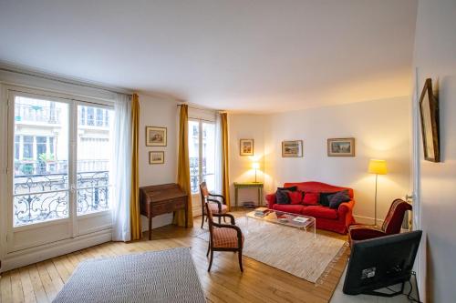 - un salon avec un canapé rouge et une fenêtre dans l'établissement Parisian Home 398 1 chambre Dupleix - Motte Piquet - Grenelle, à Paris