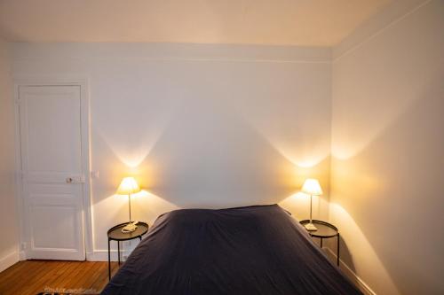 - une chambre avec deux lampes de part et d'autre d'un lit dans l'établissement Parisian Home 398 1 chambre Dupleix - Motte Piquet - Grenelle, à Paris
