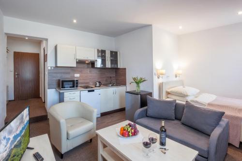 a living room with a couch and a kitchen at Hotel Kolonie in Frýdlant nad Ostravicí