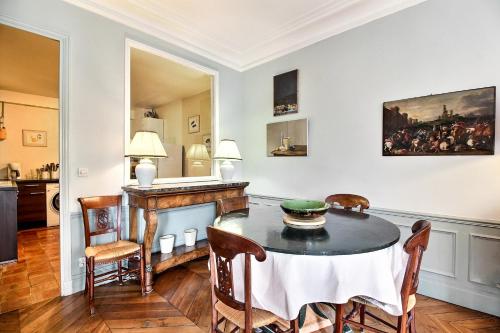 une salle à manger avec une table et des chaises dans l'établissement Parisian Home 277 2 chambres Marais - Bastille, à Paris
