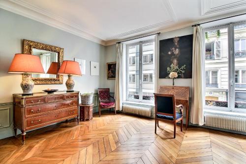 une chambre avec une commode et 2 lampes et fenêtres dans l'établissement Parisian Home 277 2 chambres Marais - Bastille, à Paris