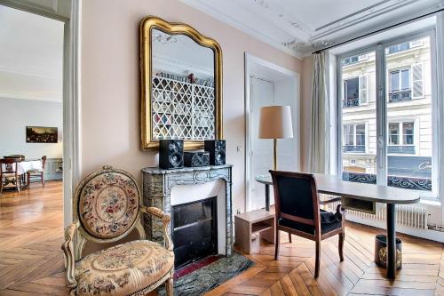 un salon avec une cheminée et un miroir dans l'établissement Parisian Home 277 2 chambres Marais - Bastille, à Paris