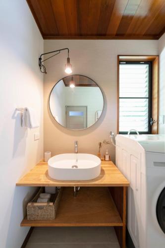 a bathroom with a sink and a mirror at YAMO-Kawana Ippekiko in Ogi