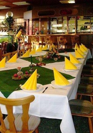 einem langen Tisch mit gelben Hüten darüber in der Unterkunft Gaststätte & Pension Am Tanger in Prenzlau