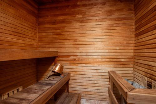 a sauna with wooden walls and benches and a bell at Hotel Tammsaare Full Automated Hotel in Pärnu