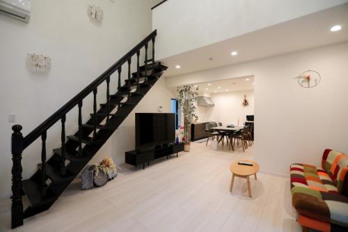 a living room with a staircase with a couch and a table at 箱根温泉別邸白鷺 天然温泉 個室サウナ癒しの貸切宿 箱根の絶景と共に最大8名宿泊可 in Hakone