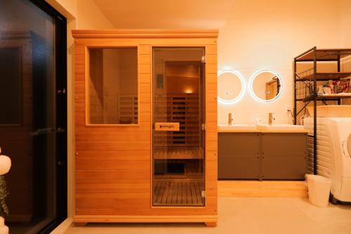 a bathroom with a glass door and a sink at 箱根温泉別邸白鷺 天然温泉 個室サウナ癒しの貸切宿 箱根の絶景と共に最大8名宿泊可 in Hakone