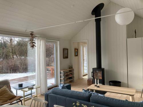 a living room with a blue couch and a fireplace at Cozy Summer House Near Rågeleje in Vejby