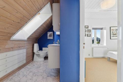 a bathroom with blue walls and a skylight at Holiday Home With Sea And Harbor View in Tranekær