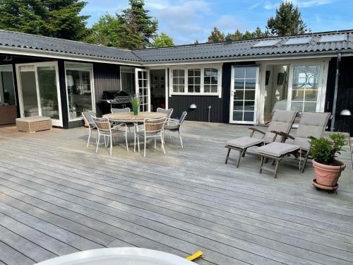 a deck with a table and chairs and a grill at Lovely Summer House By Arresø in Hillerød