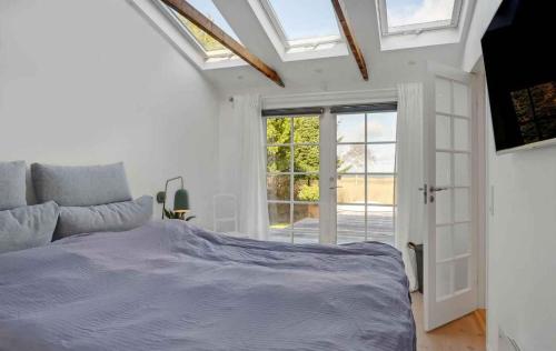 a white bedroom with a bed and a window at Lovely Summer House By Arresø in Hillerød