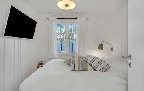 a white bedroom with a bed and a window at Lovely Summer House By Arresø in Hillerød