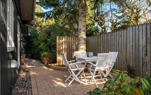 a patio with a table and chairs and a fence at Lovely Summer House By Arresø in Hillerød