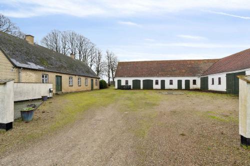 a group of white buildings with a dirt yard at Countryside Property With Great Fishing Options in Holbæk