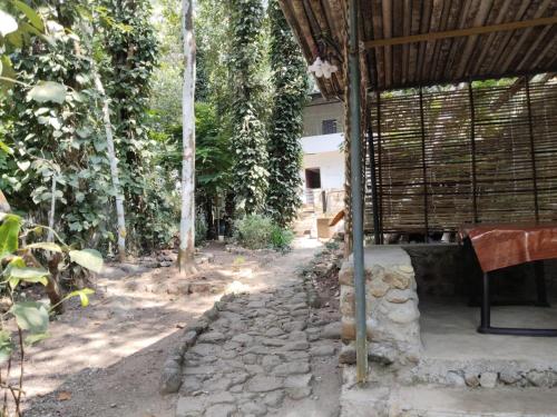 an outside area of a house with a stone path at Creekshore Home Stay in Kallar-Bridge