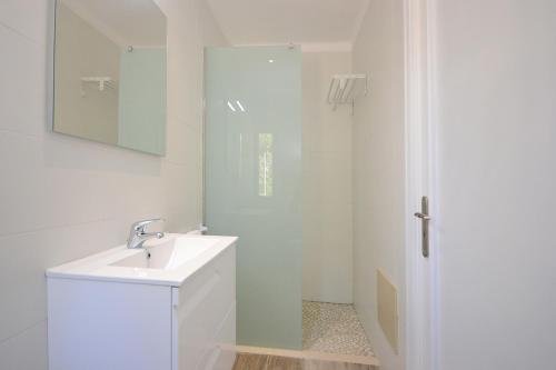 a white bathroom with a sink and a shower at House PINOCHA in Can Picafort