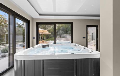 une baignoire jacuzzi dans une chambre avec fenêtres dans l'établissement Cozy Home In Icici With Sauna, à Ičići