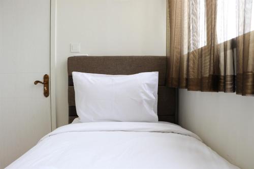 Кровать или кровати в номере Homey and Comfort Living 2BR at Daan Mogot City Apartment By Travelio