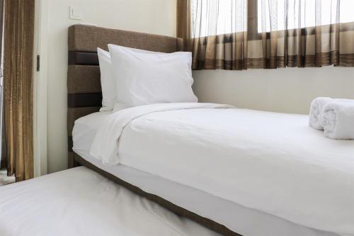 Кровать или кровати в номере Homey and Comfort Living 2BR at Daan Mogot City Apartment By Travelio