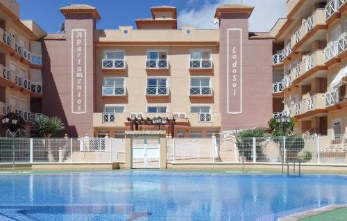ein Mehrfamilienhaus mit einem Swimmingpool davor in der Unterkunft Nice Apartment In San Pedro Del Pinatar in San Pedro del Pinatar