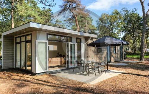 a small house with a table and an umbrella at Beautiful Home In Hellendoorn With Wifi in Hellendoorn