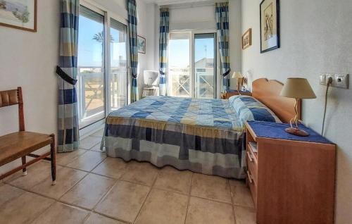 ein Schlafzimmer mit einem Bett und einem Tisch mit einer Lampe in der Unterkunft Nice Apartment In San Pedro Del Pinatar in San Pedro del Pinatar