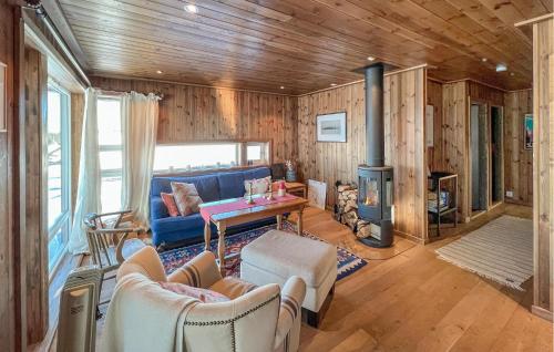 a living room with a blue couch and a fireplace at Cozy Home In Sjusjøen With Sauna in Sjusjøen