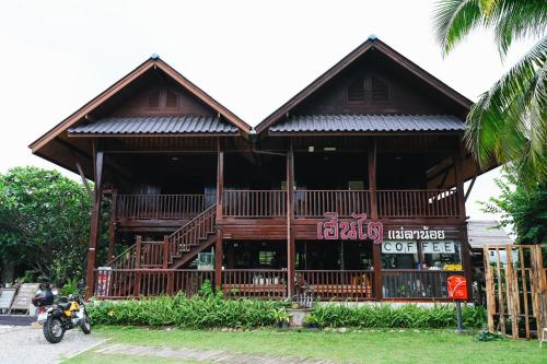 a building with a motorcycle parked in front of it at Herntai Resort Maelanoi in Ban Mae La Noi