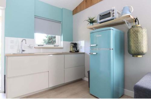 una cucina con frigorifero blu e lavandino di Rekerlanden 153 a Schoorldam