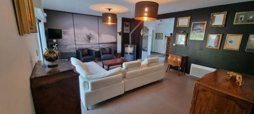 un salon avec un canapé blanc et des chaises dans l'établissement Villa Tré les Pins, 7 chambres, à 100m du LAC DE LACANAU, à Lacanau