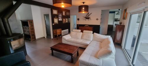 un salon avec un canapé blanc et une table basse dans l'établissement Villa Tré les Pins, 7 chambres, à 100m du LAC DE LACANAU, à Lacanau
