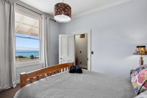 a bedroom with a bed with a view of the ocean at Moeraki Beach Haven - Otago Beachfront Home in Moeraki