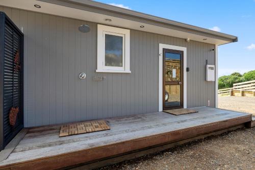 a front porch of a house with a door at Moeraki Beach Haven - Otago Beachfront Home in Moeraki