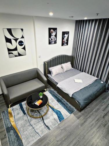 Gia Lâm PhoにあるSTUDIO 1BR, 1 giường Toà Ruby Vinhomes Ocean Parkのベッドとソファとテーブルのある寝室