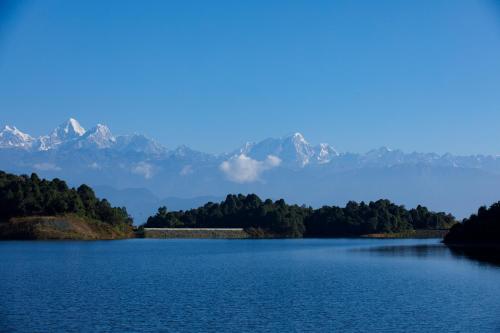 a view of a lake with mountains in the background at Prakriti Resort and Organic Farm Pvt. Ltd. in Burhānilkantha