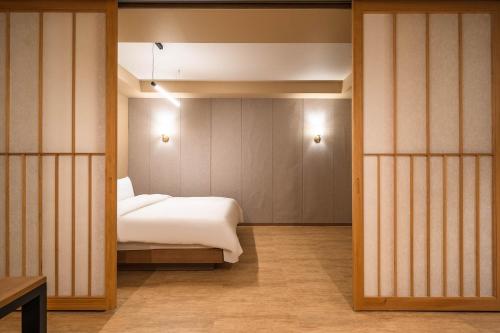 a bedroom with a bed in a room with sliding doors at Hotel New Castle Bupyeong in Incheon