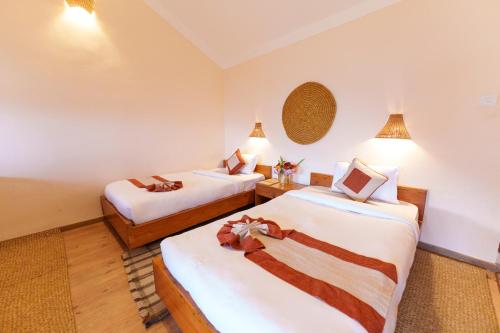 a hotel room with two beds and two lamps at Prakriti Resort and Organic Farm Pvt. Ltd. in Burhānilkantha