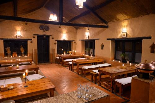 a large dining room with wooden tables and chairs at Prakriti Resort and Organic Farm Pvt. Ltd. in Burhānilkantha