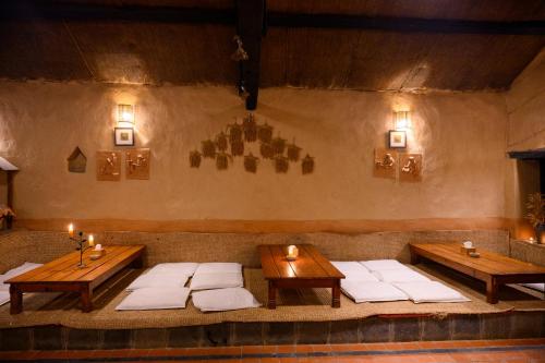 a room with two tables and white pillows at Prakriti Resort and Organic Farm Pvt. Ltd. in Burhānilkantha